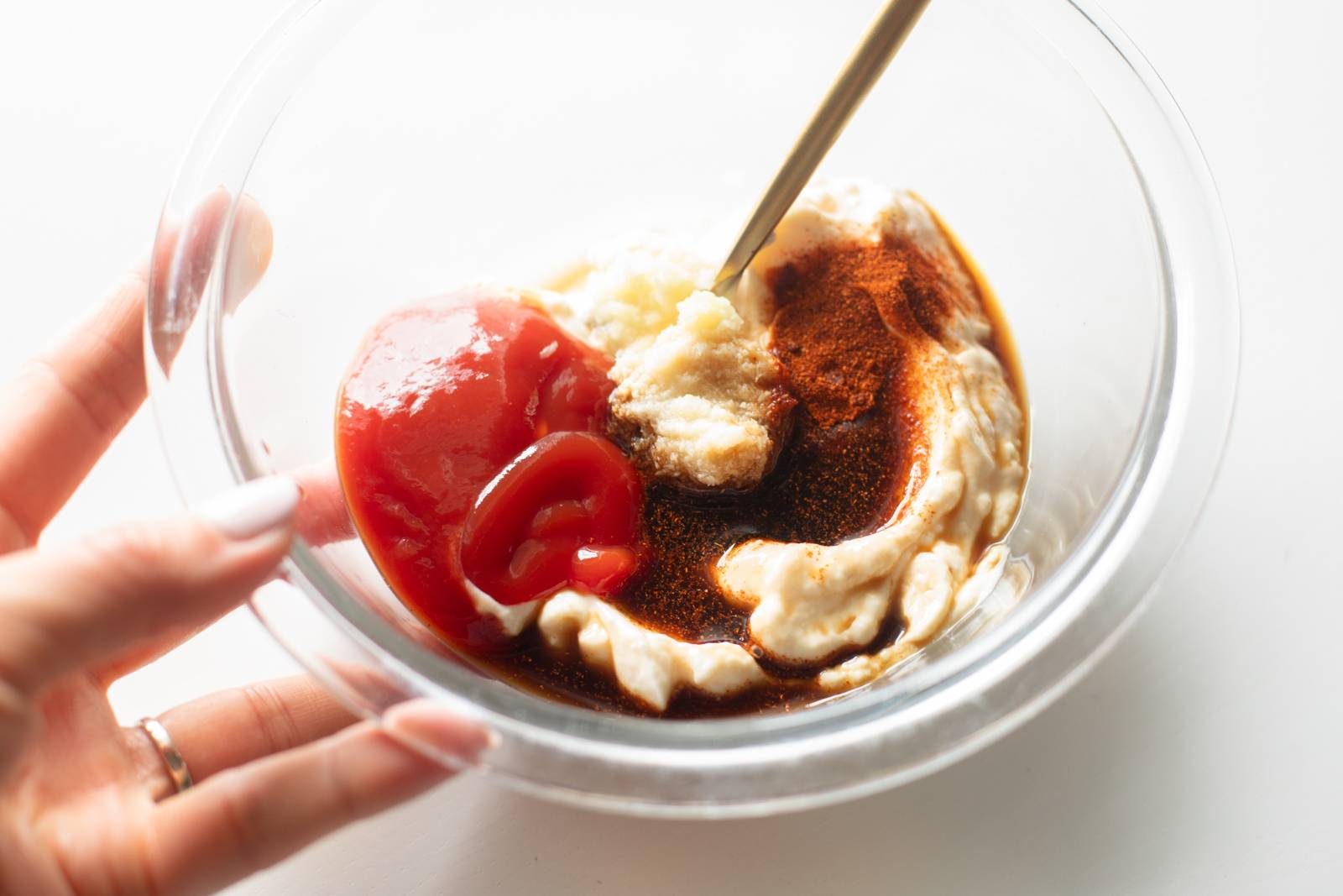 Mixing house sauce in a bowl.
