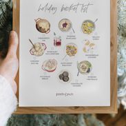 Holiday bucket list in a frame in front of a holiday tree.