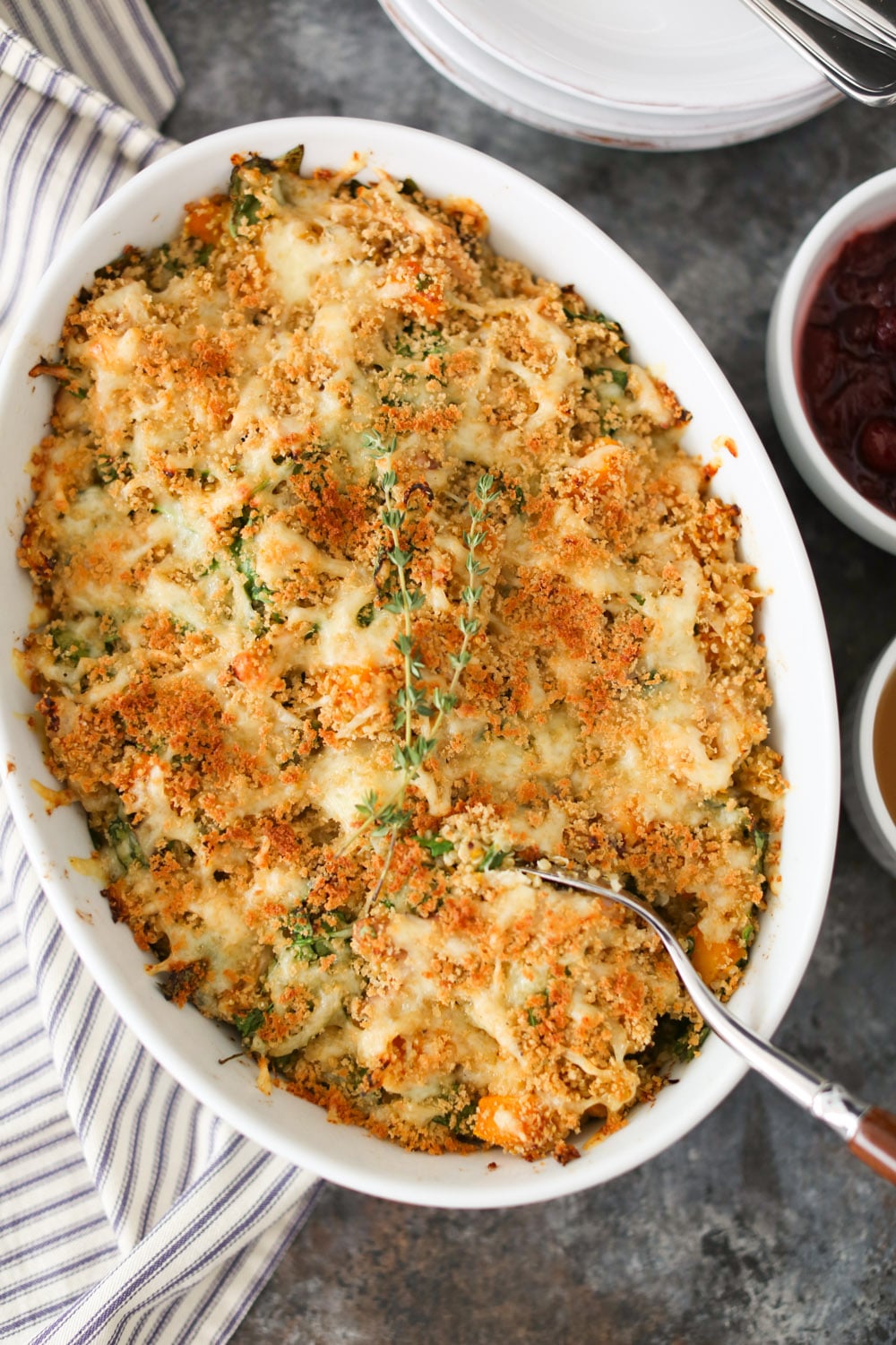 Overhead view of Thanksgiving Quinoa Bake in a casserole dish with a serving spoon breaking the surface of the casserole. 