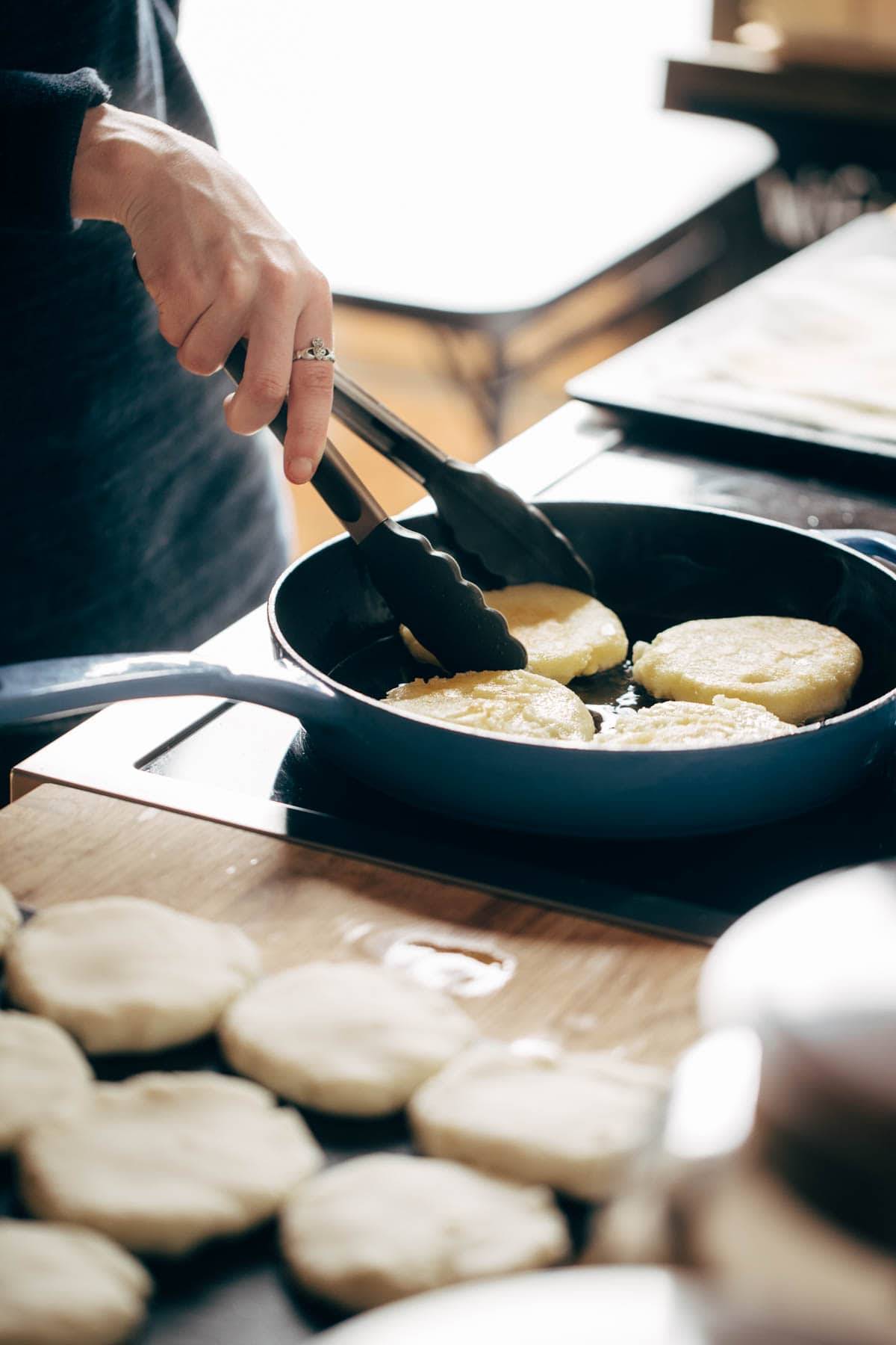 Frying Arepas in a pan.