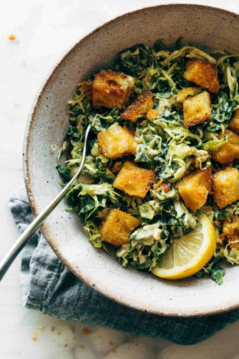 Brussels and kale caesar in a bowl with croutons.
