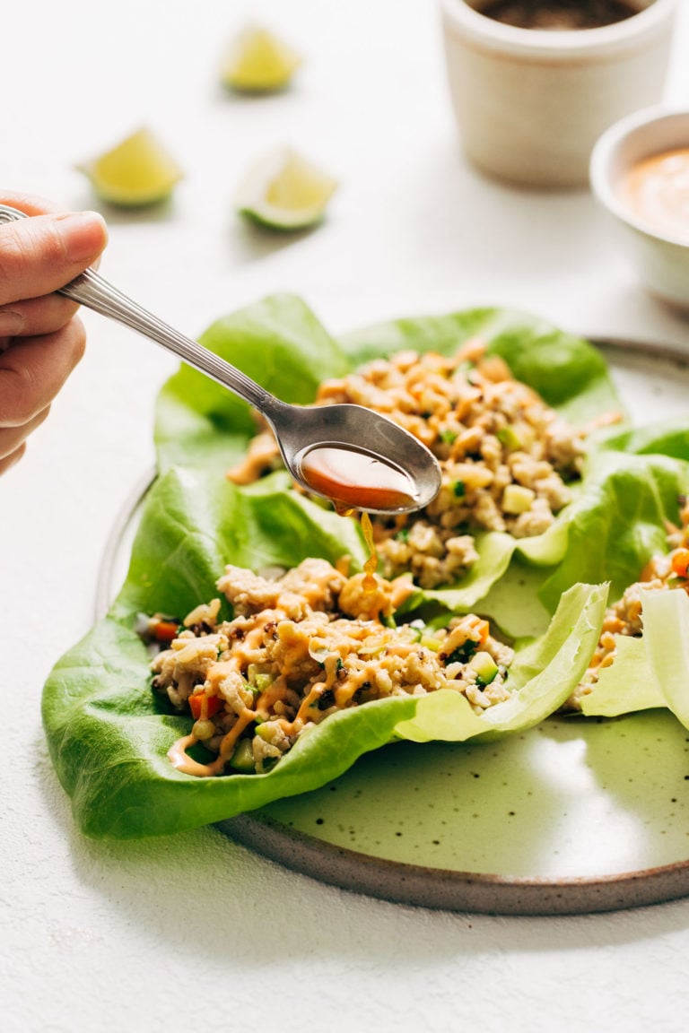 Chicken lettuce wraps with sauce poured on top.