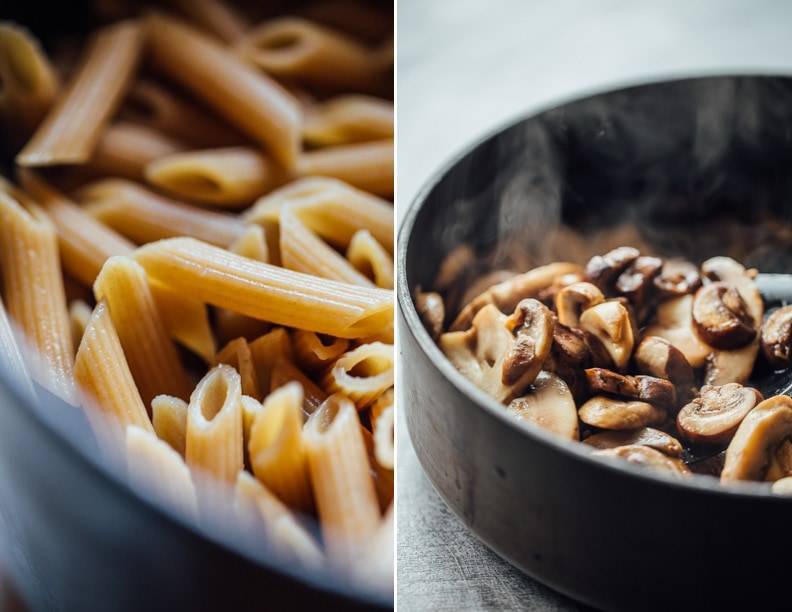 Noodles and mushrooms steaming in a pan.